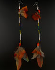 Pair of feather earrings on a black background
