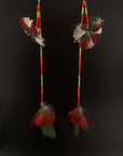 Pair of feather earrings with colorful beads on a black background
