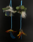 Feather earrings with blue beads on a black background