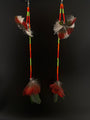 Pair of feather earrings with colorful beads on a black background