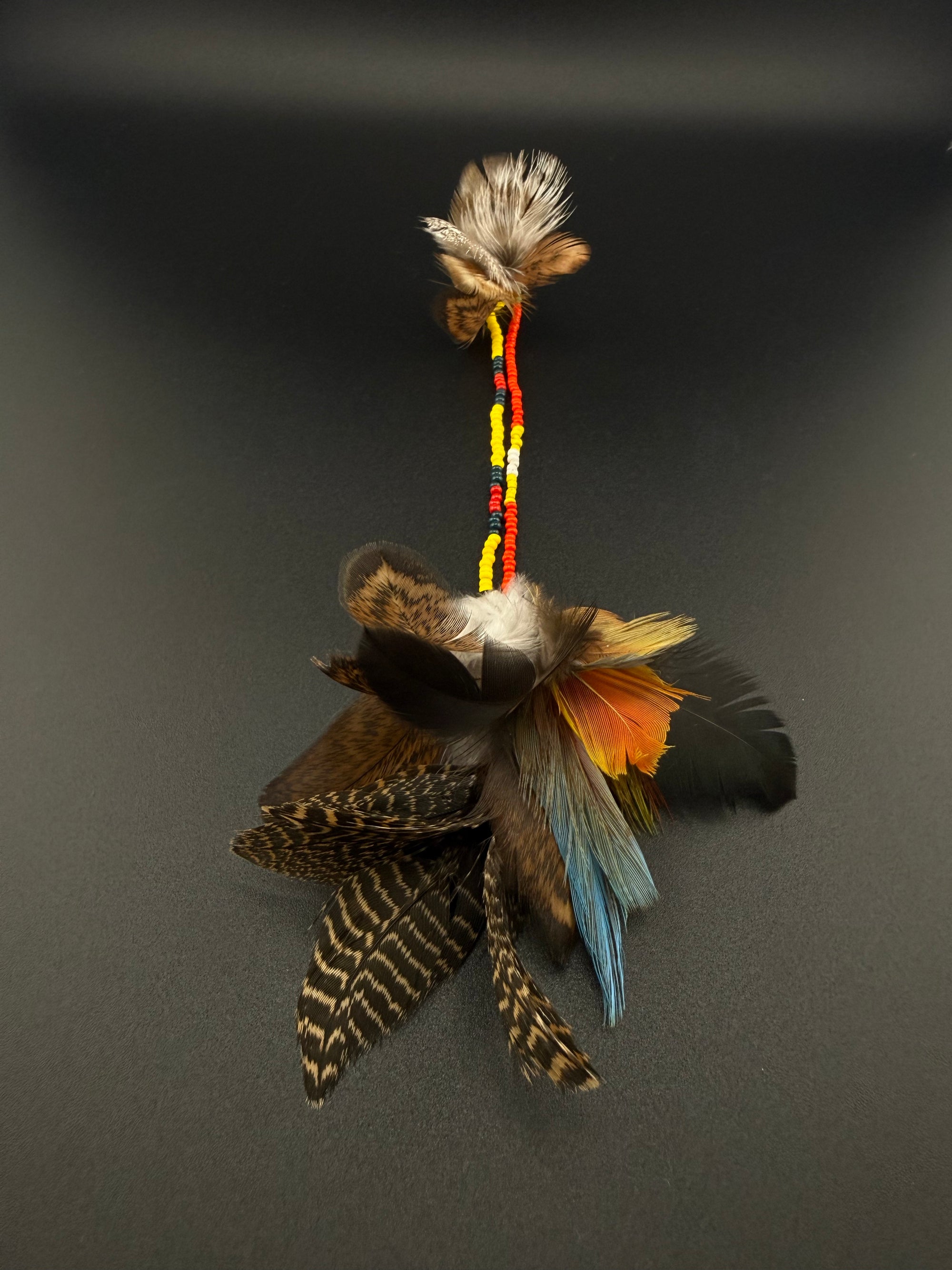 A long decorative feather and bead hair clip by Huni Kuin artisans 