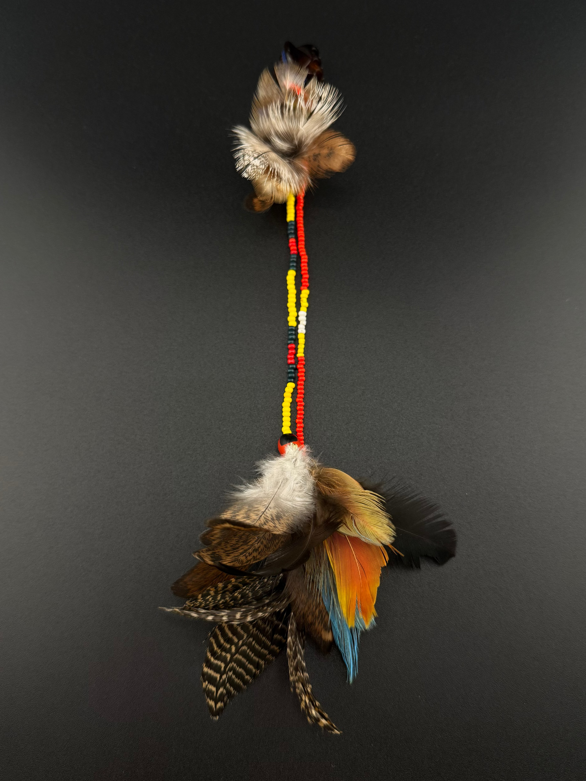 A long decorative feather and bead hair clip by Huni Kuin artisans 