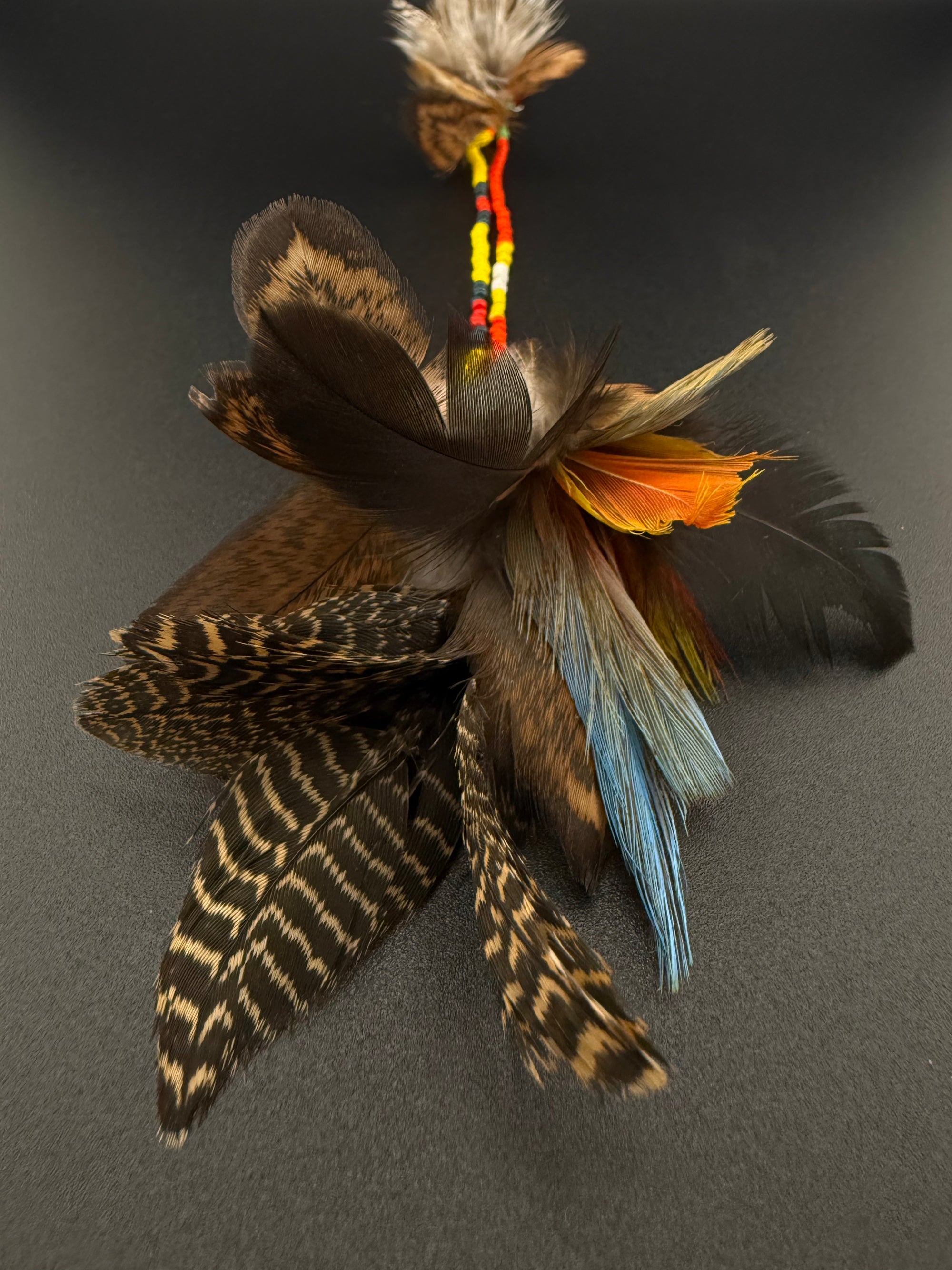 A long decorative feather and bead hair clip by Huni Kuin artisans 
